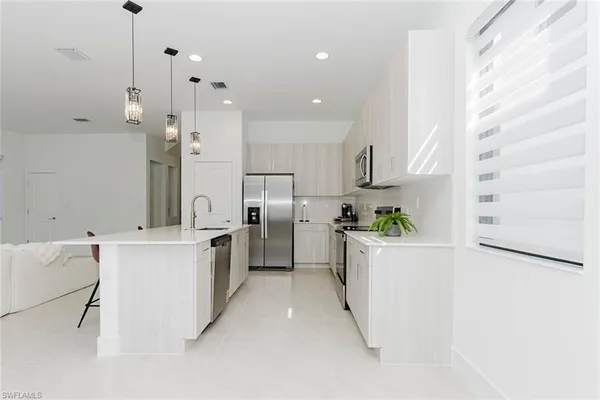 a kitchen with white cabinets and white appliances