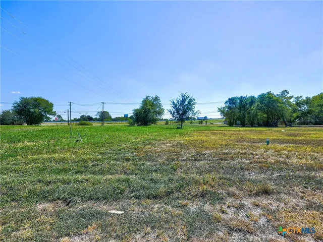 a view of a green field with wooden fence