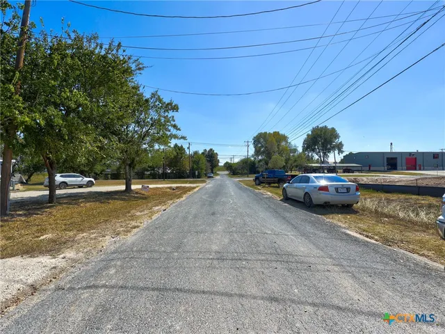 a view of a street with a car parked on the road