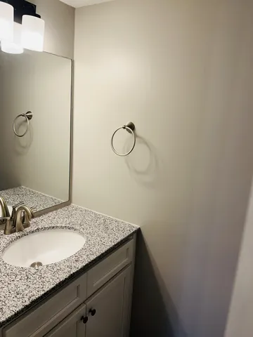 a bathroom with a granite countertop sink and vanity
