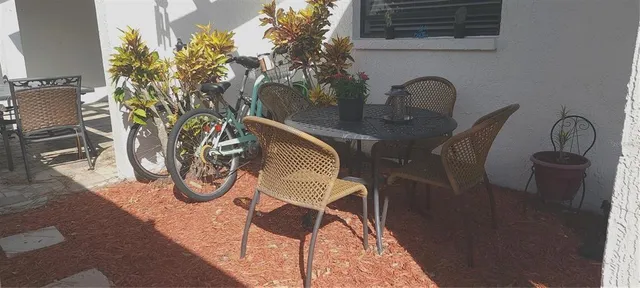 a table with chairs and potted plant on it
