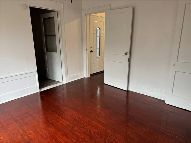 an empty room with wooden floor and closet