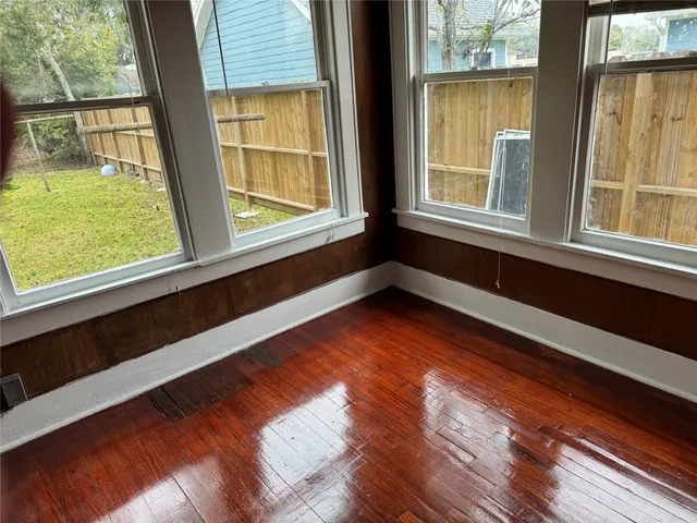 a view of a room with wooden floor and windows