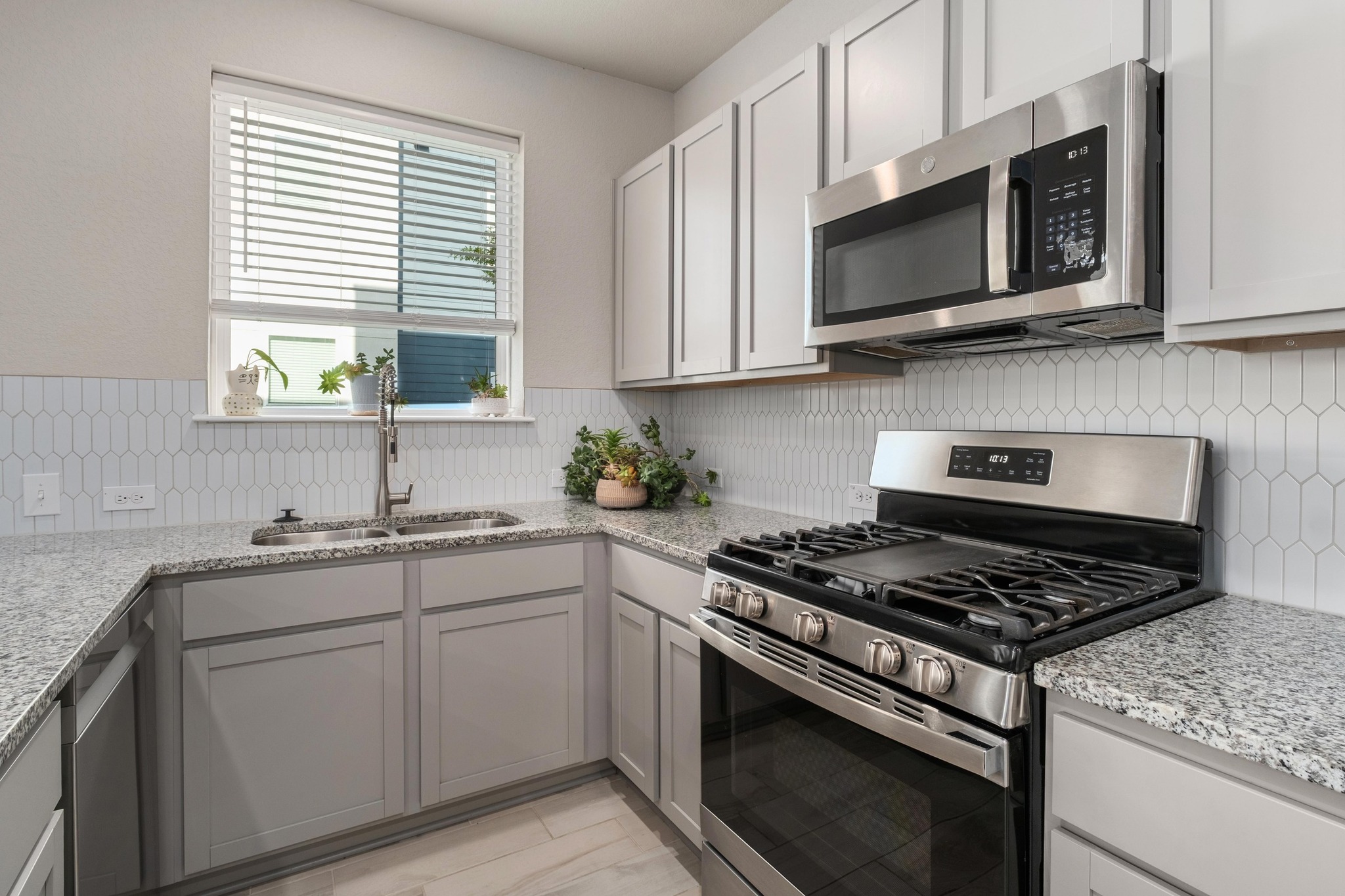 9015 Cattle Baron Path, Unit 1905 Austin, TX 78747 - Photo 11 of 40 a kitchen with stainless steel appliances granite countertop white cabinets a sink and a stove