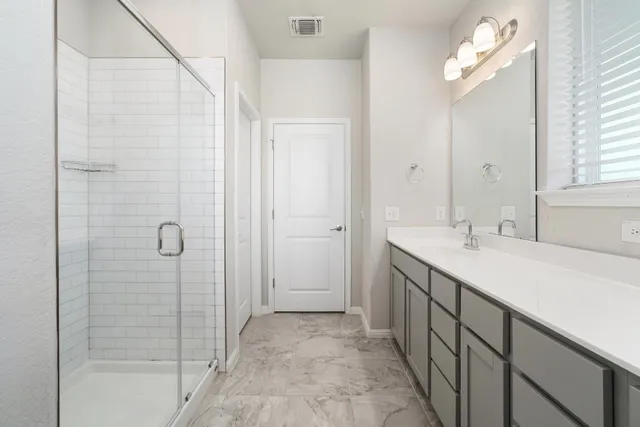 a bathroom with double sink and a mirror