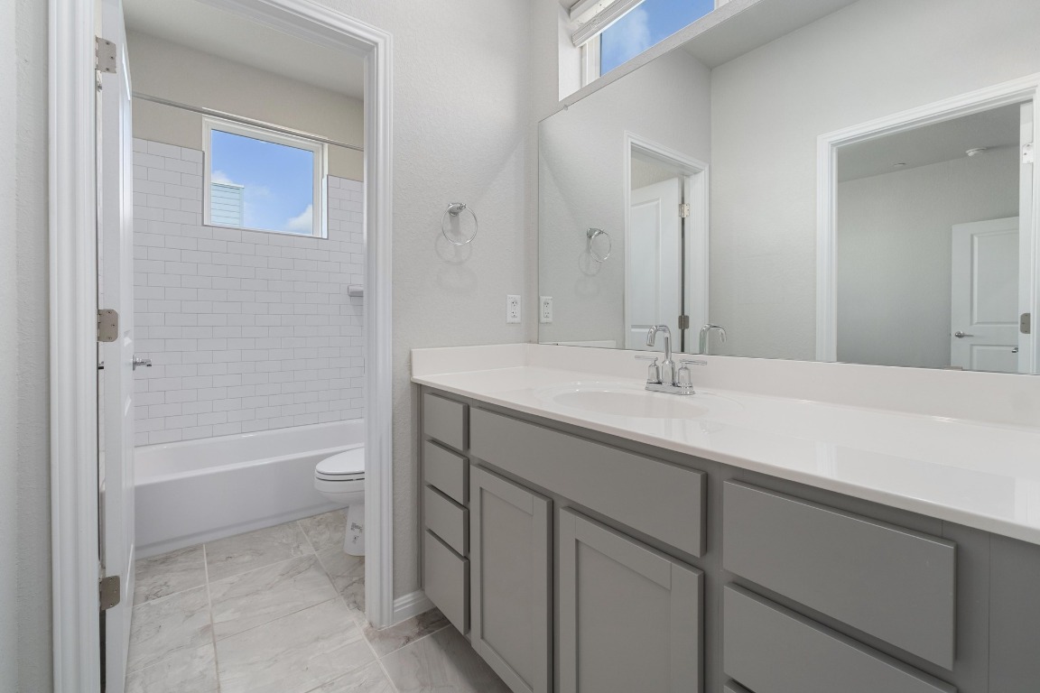 9015 Cattle Baron Path, Unit 1905 Austin, TX 78747 - Photo 23 of 40 a bathroom with a sink a toilet and shower