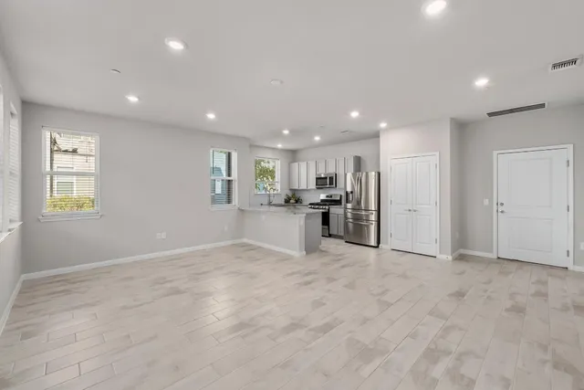 a view of kitchen with refrigerator and windows