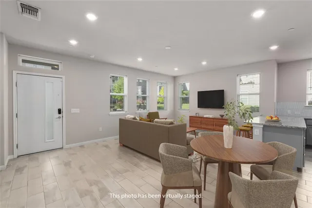 a living room with furniture a flat screen tv and kitchen view