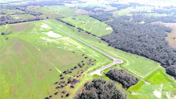 an aerial view of a golf course with a lake view