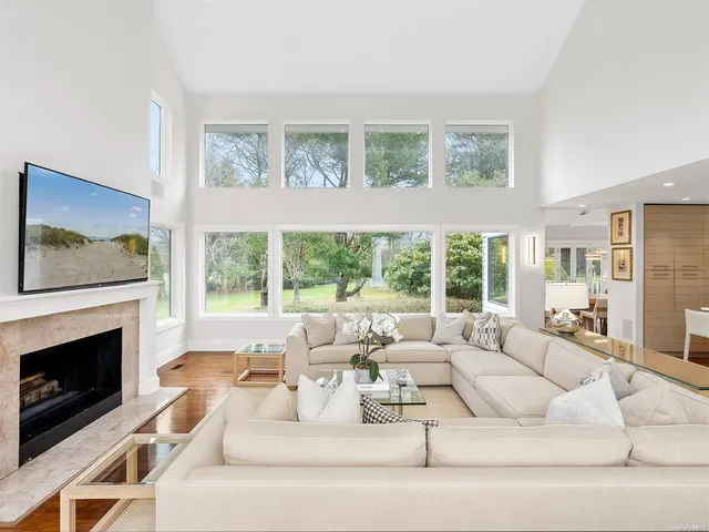 a living room with furniture large windows and a fireplace