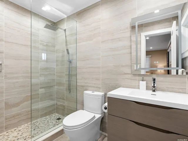 a bathroom with a sink a toilet and shower