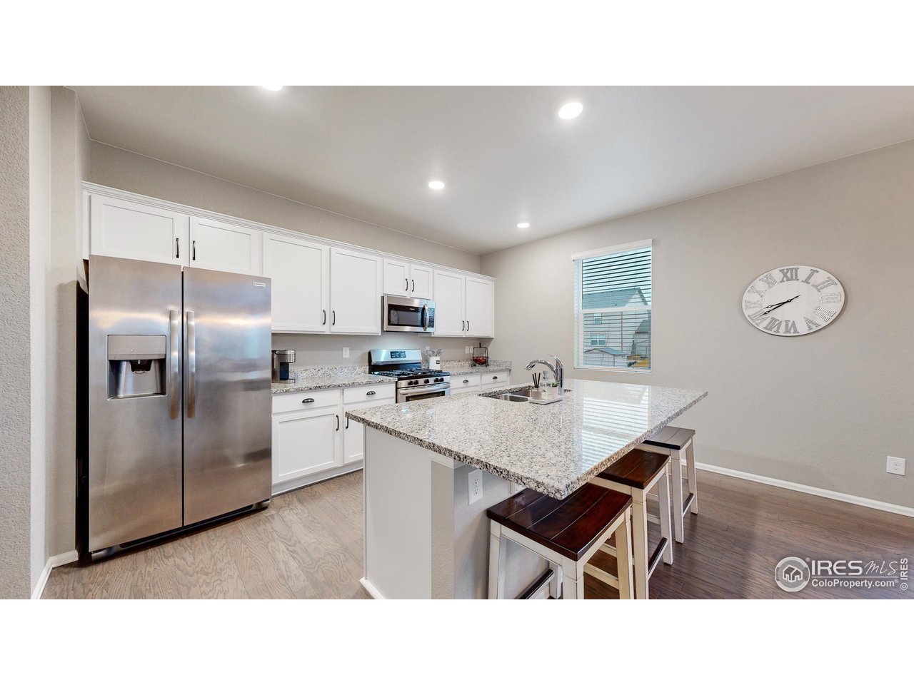 933 Keneally Court Windsor, CO 80550 - Photo 3 of 40 a kitchen with a sink stainless steel appliances and view living room