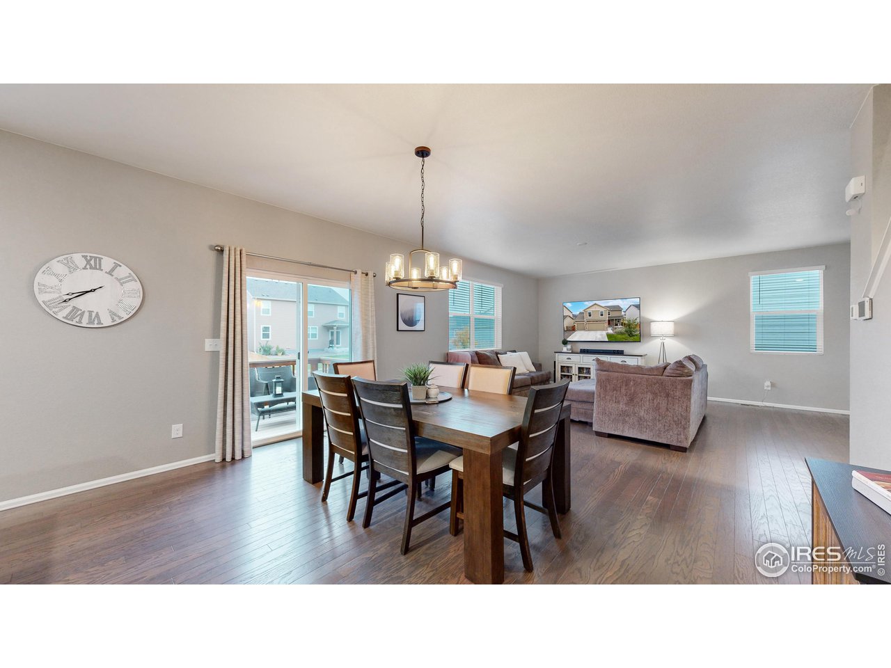 933 Keneally Court Windsor, CO 80550 - Photo 8 of 40 a dining room with wooden floor a chandelier a wooden table and chairs