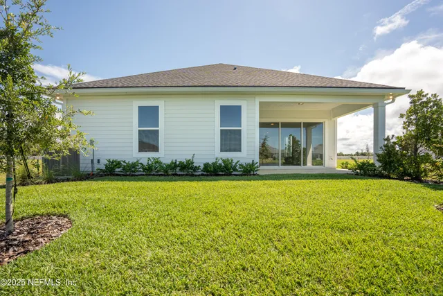 a large kitchen with stainless steel appliances granite countertop a stove a sink and white cabinets with wooden floor