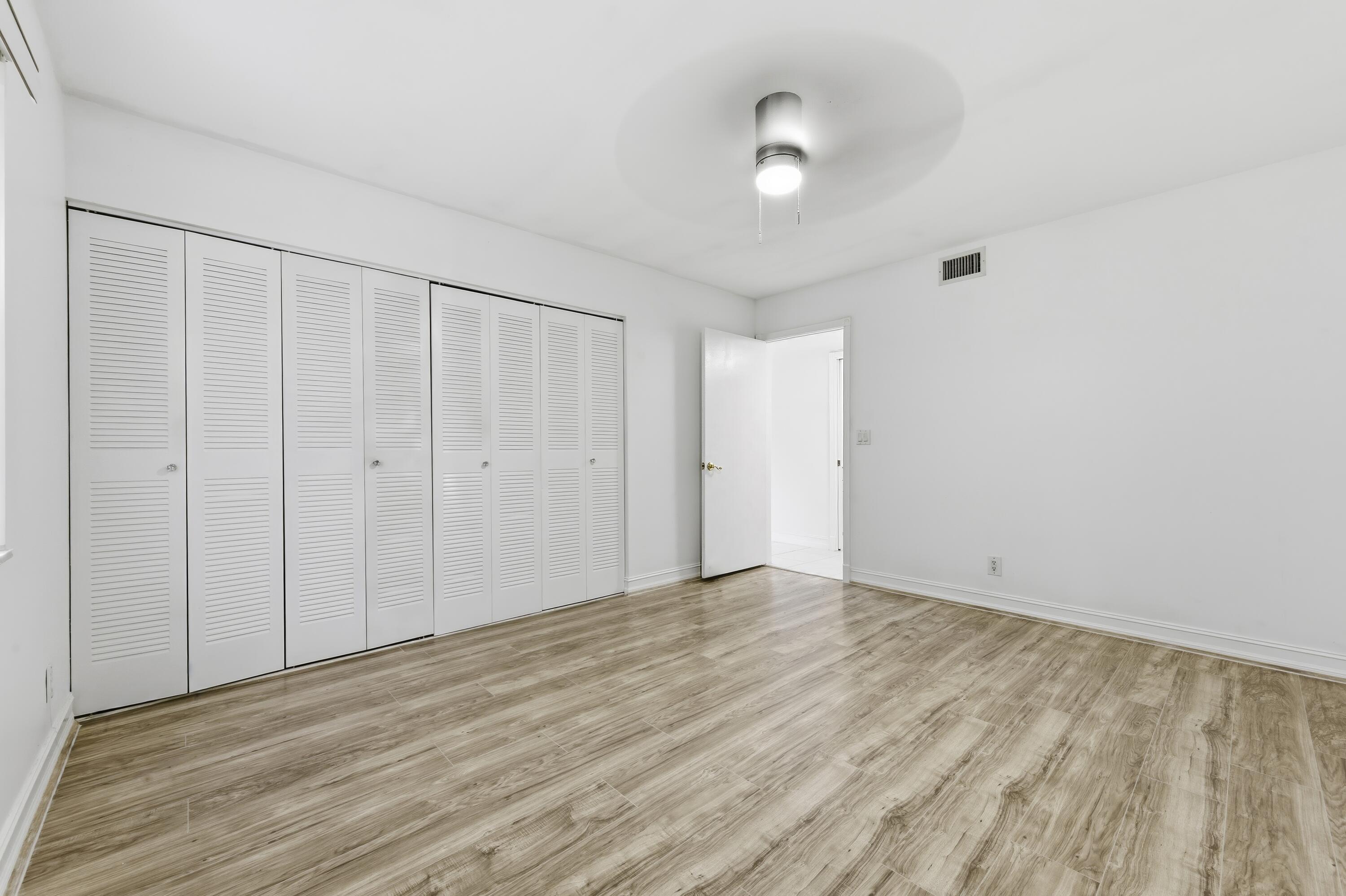 1167 South Drive Circle, Unit D Delray Beach, FL 33445 - Photo 12 of 26 a view of an empty room with wooden floor