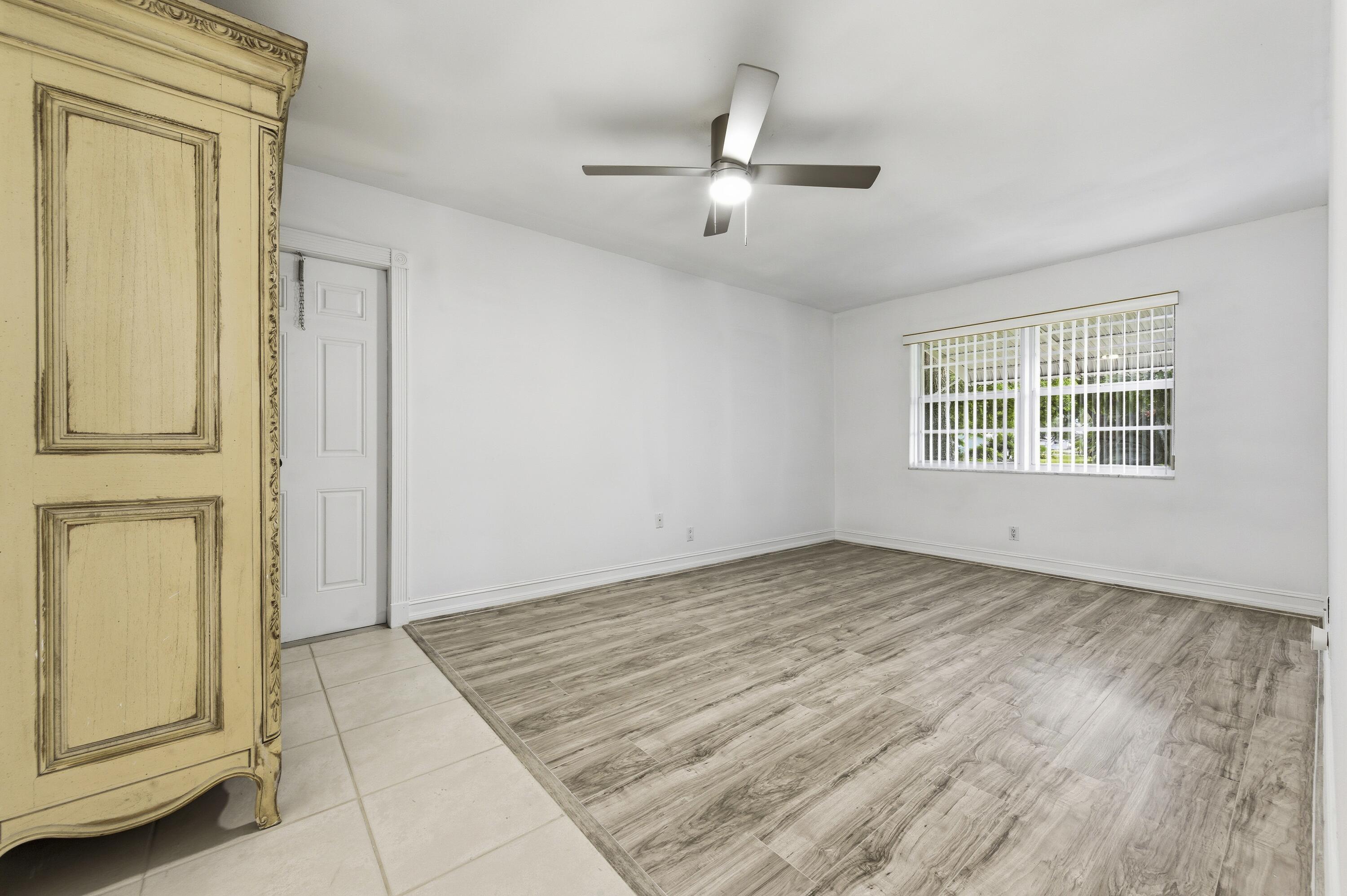 1167 South Drive Circle, Unit D Delray Beach, FL 33445 - Photo 18 of 26 a view of an empty room with wooden floor and a window