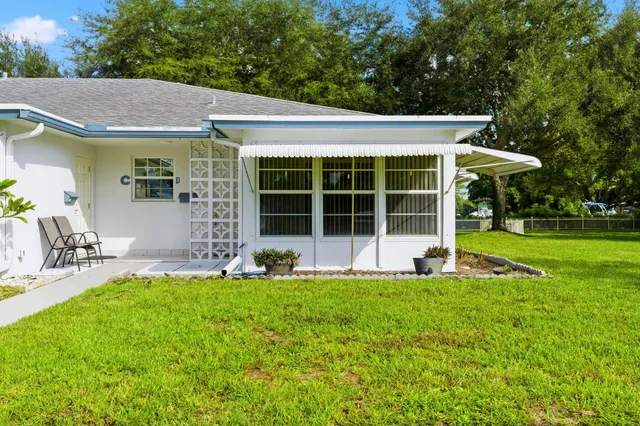 a view of a house with a yard and sitting area