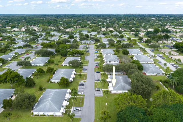 an aerial view of residential houses with outdoor space and trees