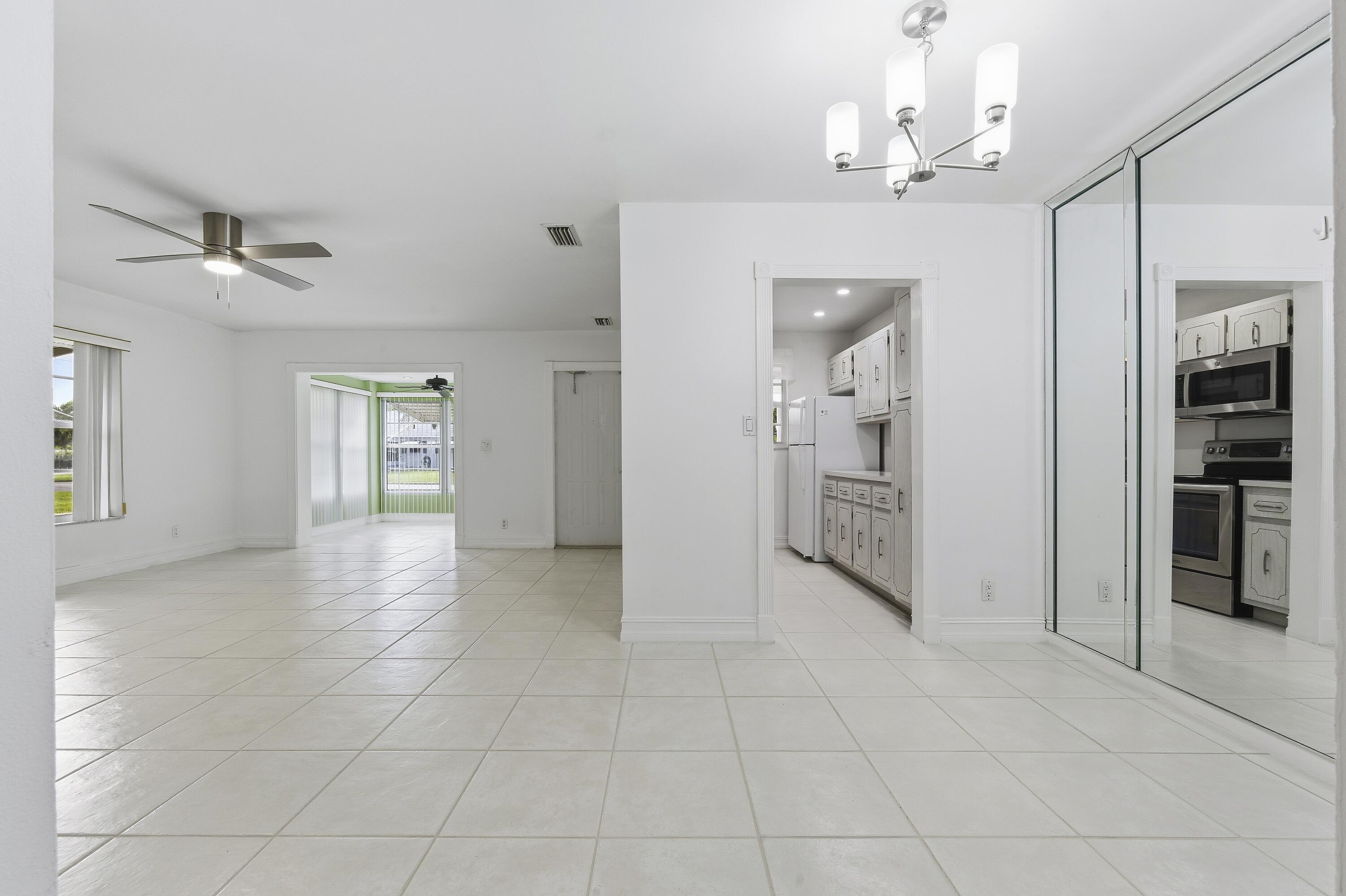 1167 South Drive Circle, Unit D Delray Beach, FL 33445 - Photo 6 of 26 a view of a hallway with wooden floor and a kitchen