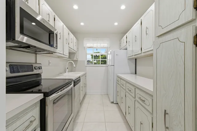 a kitchen with stainless steel appliances granite countertop a refrigerator and a stove