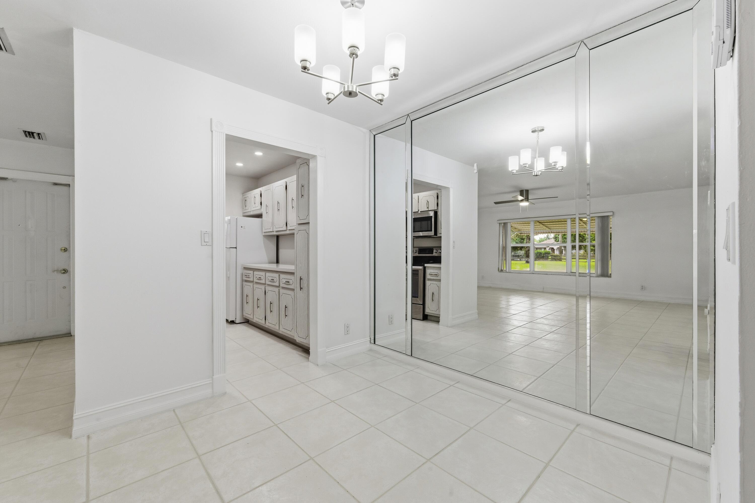 1167 South Drive Circle, Unit D Delray Beach, FL 33445 - Photo 8 of 26 a view of a hallway with a chandelier