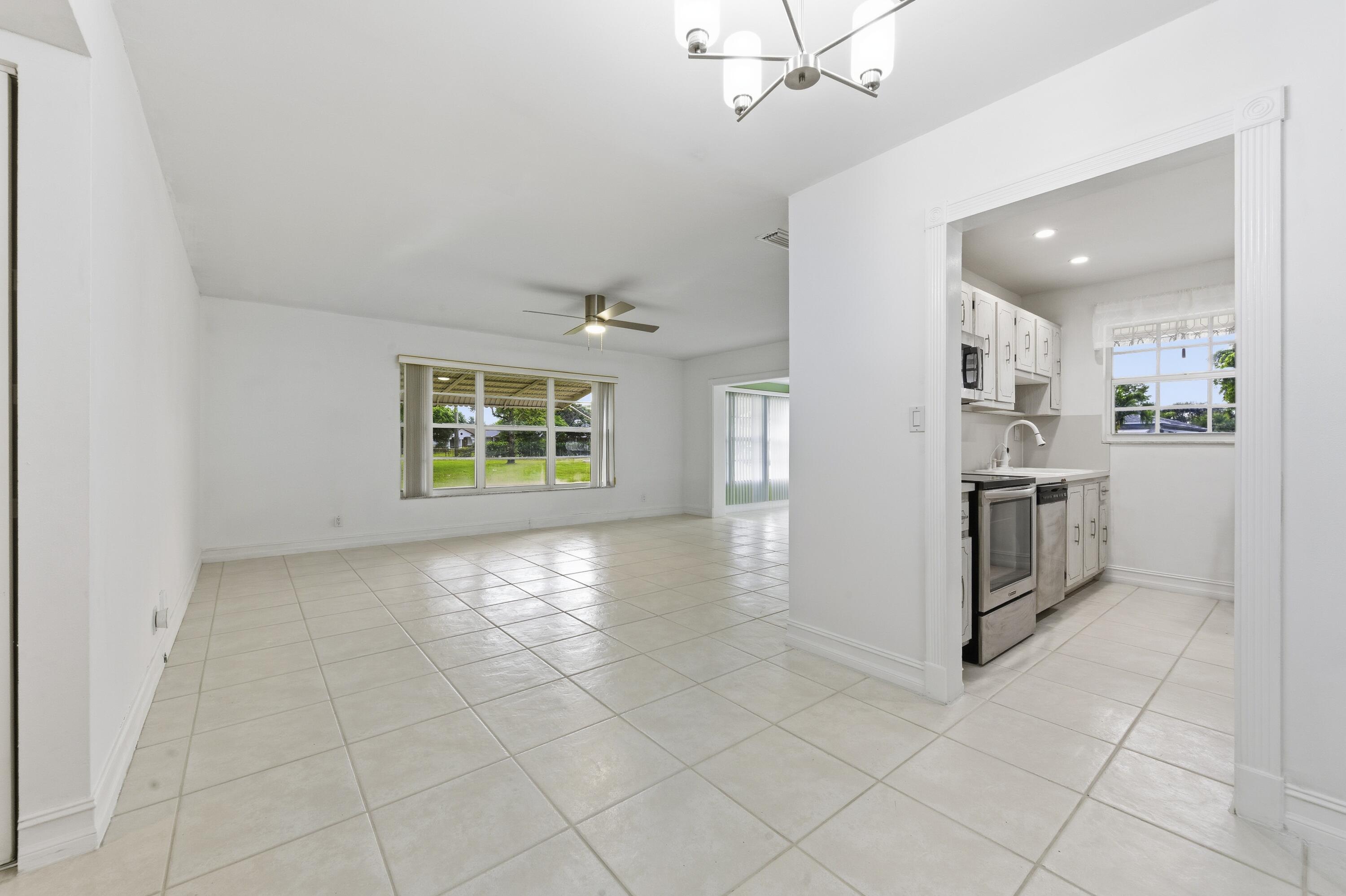 1167 South Drive Circle, Unit D Delray Beach, FL 33445 - Photo 9 of 26 an empty room with kitchen and windows