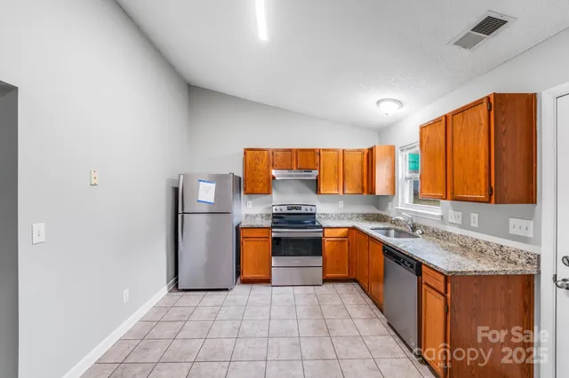 a kitchen with stainless steel appliances granite countertop a stove a sink and a microwave