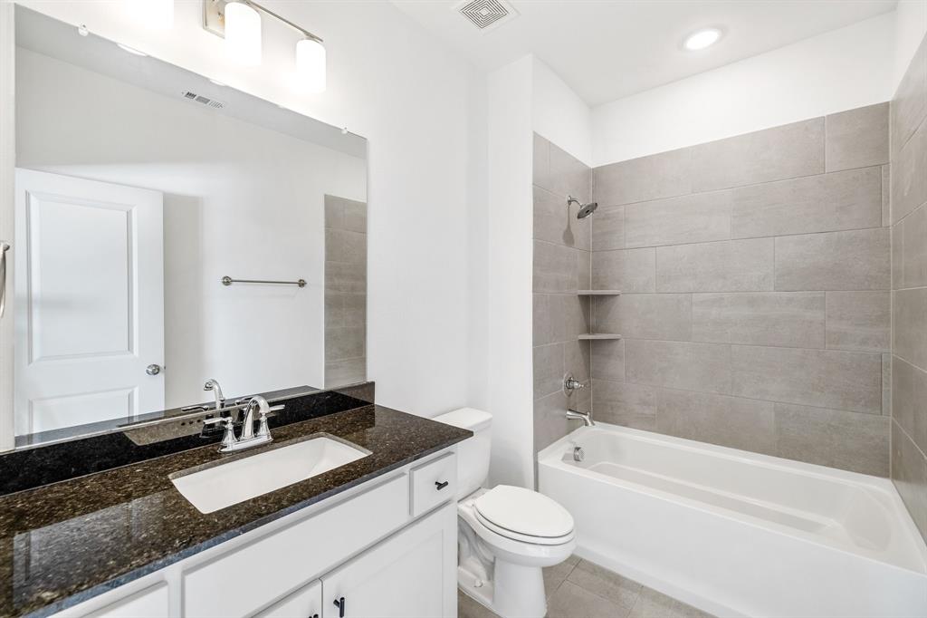 699 Vista Oak Road Lewisville, TX 75067 - Photo 20 of 35 a bathroom with a granite countertop sink mirror toilet and bathtub
