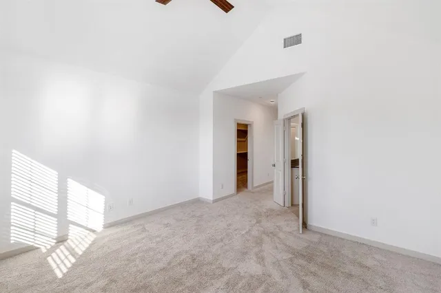 an empty room with a hallway and wooden floor