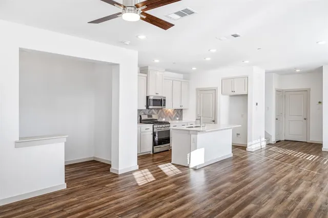 a kitchen with a refrigerator and white cabinets