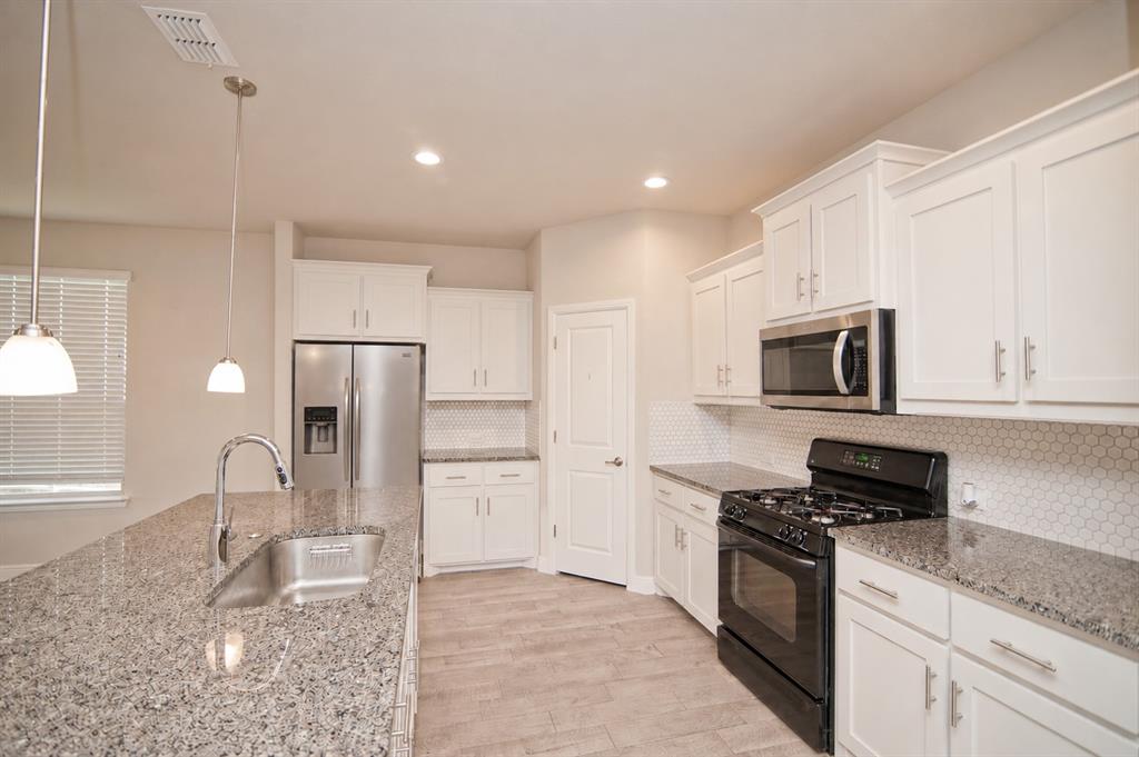 1804 Mensa Drive Haslet, TX 76052 - Photo 6 of 30 Kitchen featuring white shaker-style cabinetry, granite countertops, and a hexagonal tile backsplash