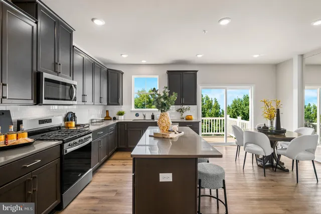 a kitchen with stainless steel appliances granite countertop sink stove top oven and cabinets