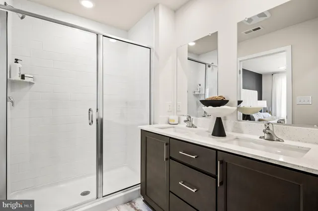 a bathroom with a double vanity sink mirror and shower