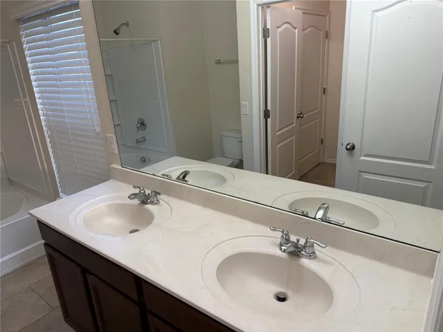 a bathroom with a granite countertop bathtub shower and toilet