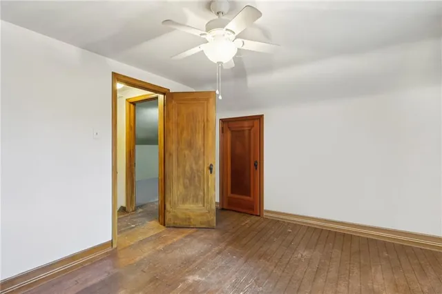an empty room with closet and a chandelier fan