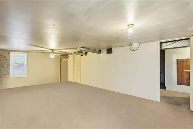 en empty room with windows and ceiling fan