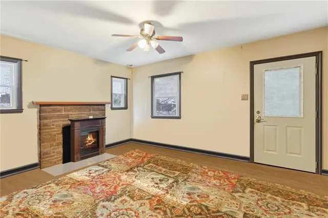 a view of an empty room with a fireplace and a window