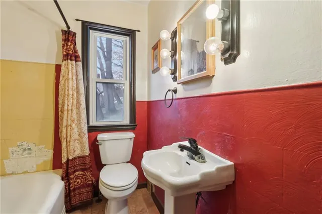 a bathroom with a sink mirror and toilet