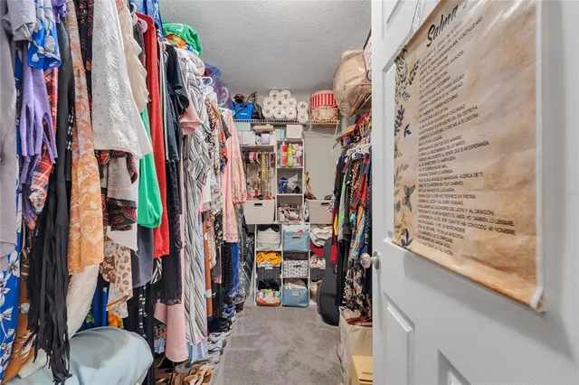 a view of walk in closet with clothes