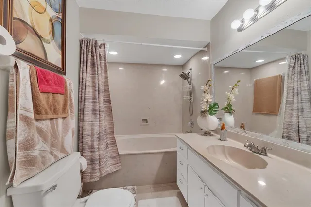 a bathroom with a granite countertop sink a toilet and shower