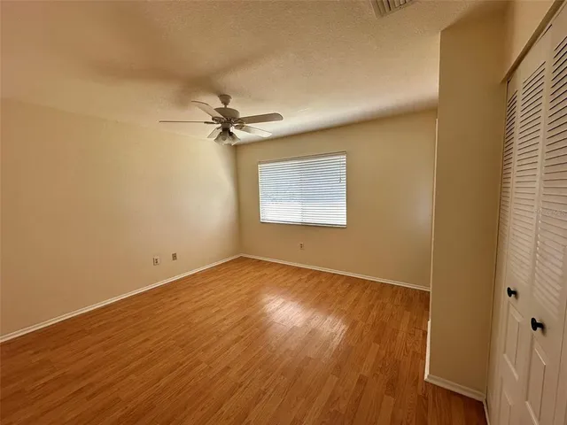 a view of an empty room with a window and wooden floor