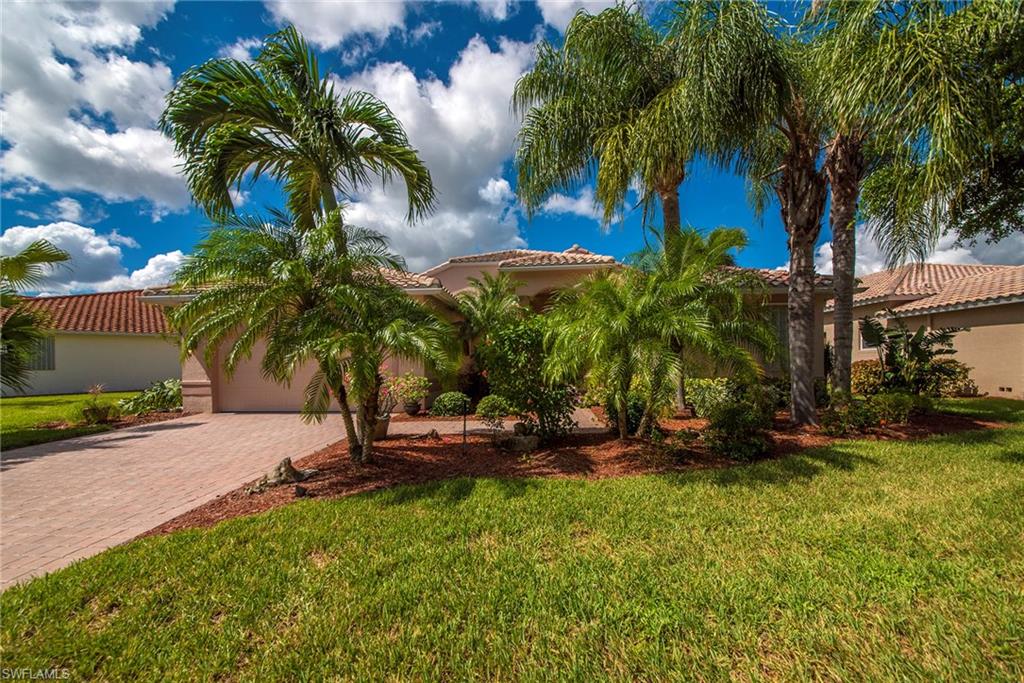 20483 Foxworth Circle Estero, FL 33928 - Photo 2 of 25 a view of a backyard with a garden and palm trees