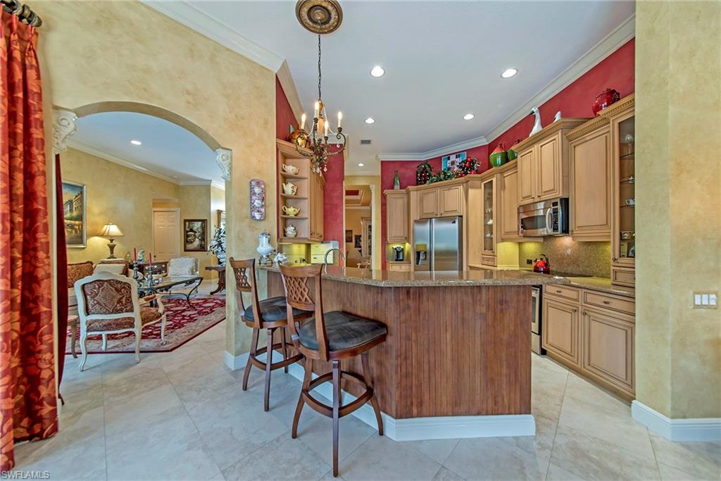 20483 Foxworth Circle Estero, FL 33928 - Photo 9 of 25 a kitchen with stainless steel appliances kitchen island granite countertop a table and chairs in it