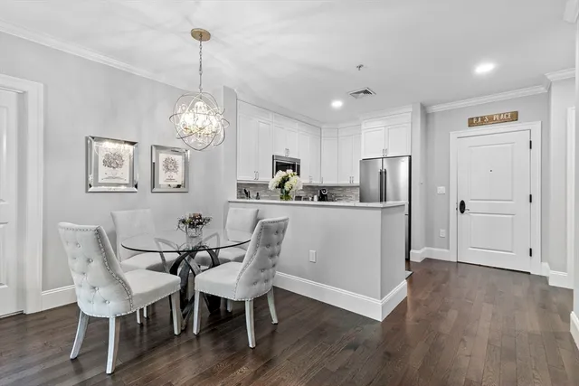 a dining room with furniture a chandelier and wooden floor