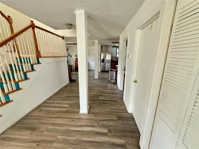 a view of a hallway with wooden floor and staircase
