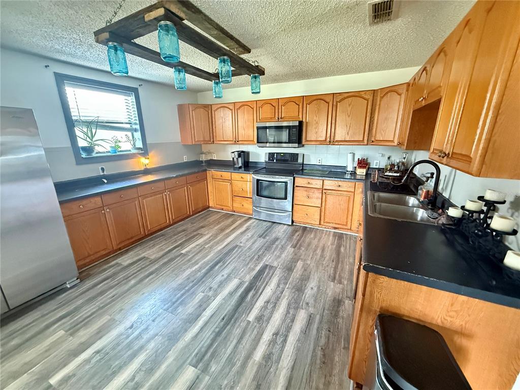 439 Corbett Road Lithia, FL 33547 - Photo 6 of 27 a kitchen with stainless steel appliances granite countertop a sink dishwasher stove and refrigerator