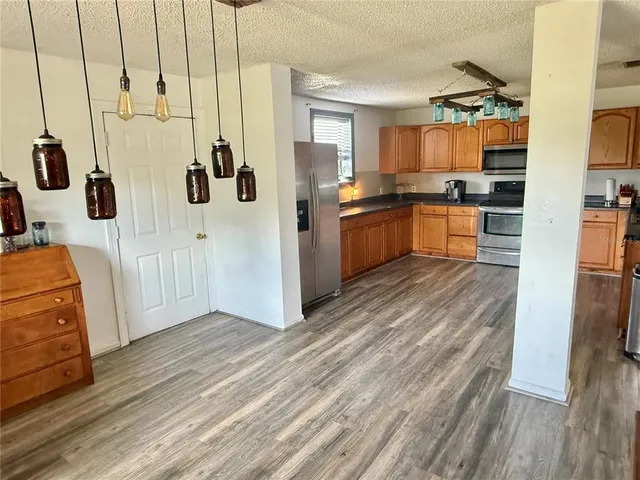 a kitchen with stainless steel appliances a refrigerator and wooden floor