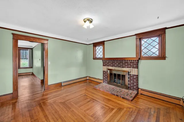 a living room with wooden floor and a fireplace