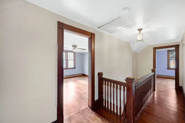 a view of a hallway with entryway and wooden floor