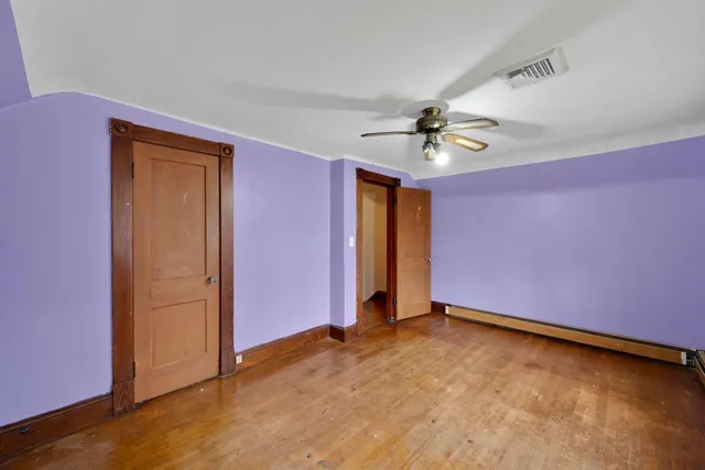 an empty room with closet and a ceiling fan